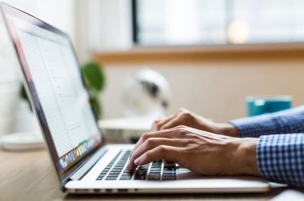 individual typing on laptop