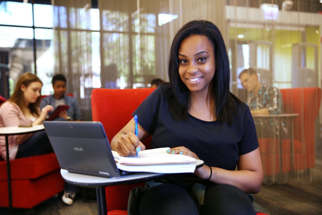 Student on laptop smiling