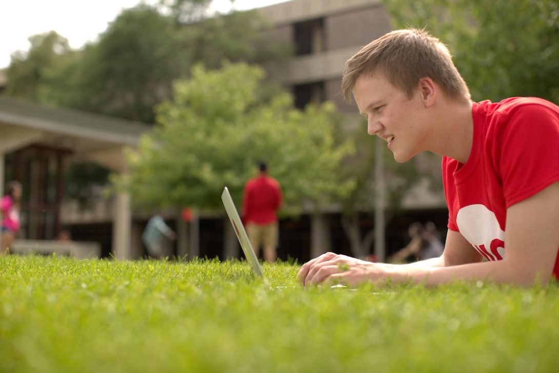 Image of student with laptop on UIC Campus