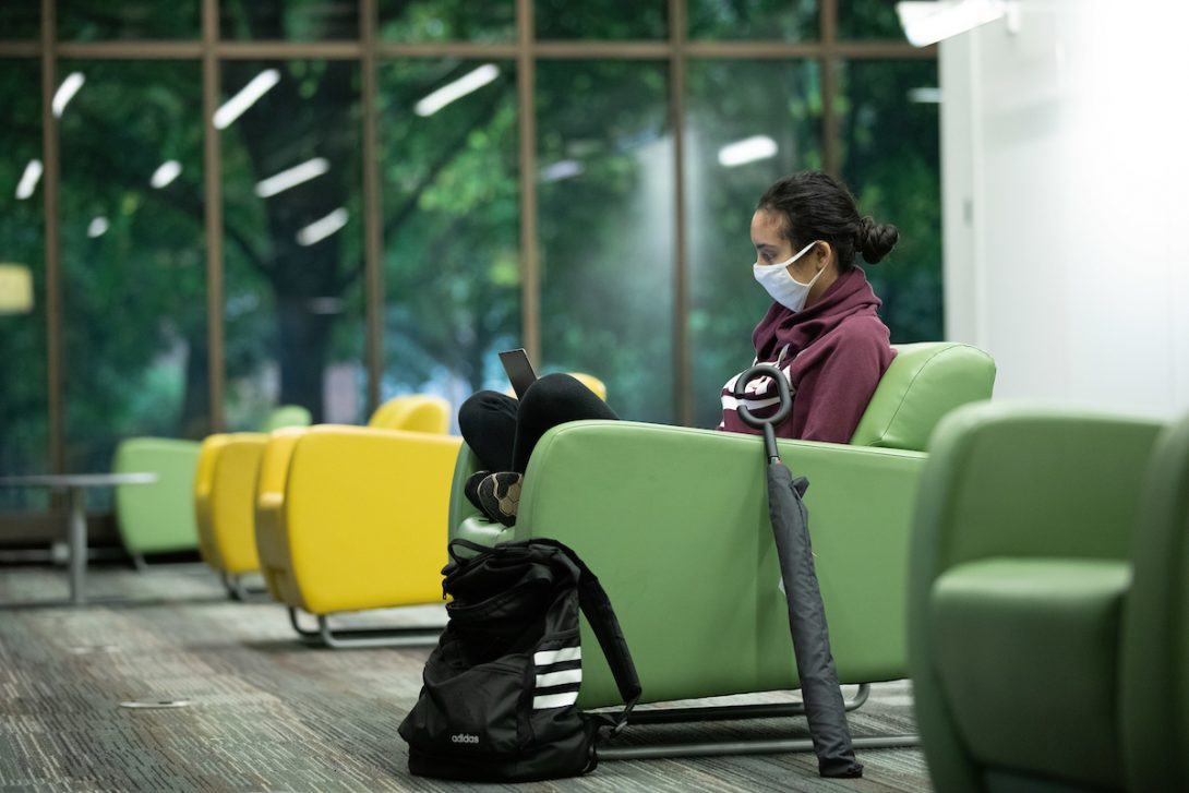 Student at UIC Library wearing mask