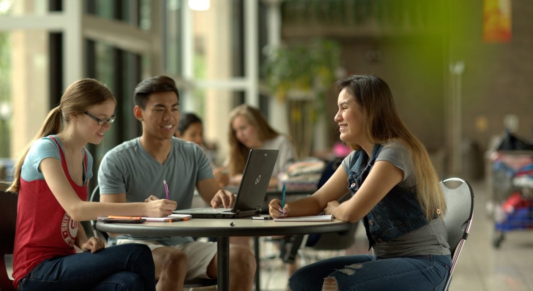 Image of students at UIC around laptop