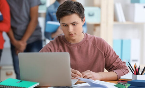 Student focusing on work on laptop