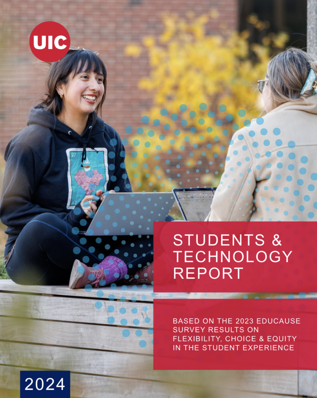 Two female students with laptops on campus