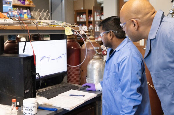 two individuals working on a project and looking at the results on computer