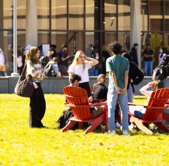 students sitting together on campus
                  