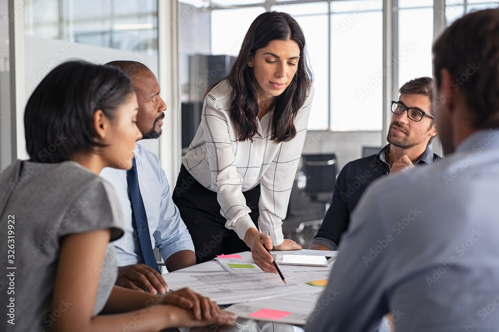 People gathered in an office meeting and one person taking the lead
